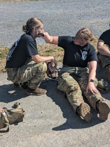 Cadet Madison Cappellano '24 applies camo to Cadet Janine Colantonio '23 for Ranger Challenge training.