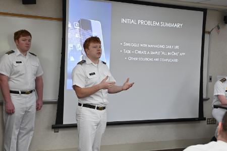 Cole Bowyer ’25 discusses the app his team developed to assist veterans with traumatic brain injury as team member Liam Noonan ’25 looks on.