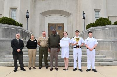 Maj. Gen. Cedric T. Wins ’85 congratulates cadets on the Ethics Team, Suzanne Leaptrot ’25, Riley Malone ’25, and Ryan Manning ’26, along with their coaches Reshef Agam-Segal, Ph.D., and Cmdr. Julie Shank, and mentor, Col. Pat Looney. Not pictured is Kaiden Minter ’26.