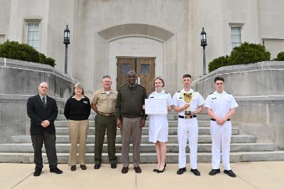Maj. Gen. Cedric T. Wins ’85 congratulates cadets on the Ethics Team, Suzanne Leaptrot ’25, Riley Malone ’25, and Ryan Manning ’26, along with their coaches Reshef Agam-Segal, Ph.D., and Cmdr. Julie Shank, and mentor, Col. Pat Looney. Not pictured is Kaiden Minter ’26.