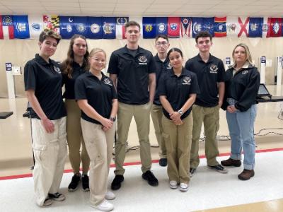 Pistol club members Tiffany Rock ’28, Sofia Fleming ’28, Kate Patrick ’27, Chris Olsen ’25, Bill Gray ’27, Jamie Palacio ’27, Chase Boucher ’27, and asst. coach Jan Downs celebrate their achievement. Not pictured are head coach Reese McCormick and Andrei Hipol ’28