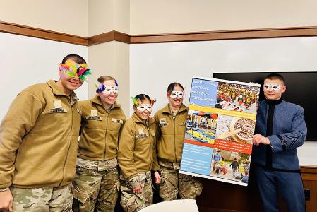 Students (cadets) at VMI, a military college, hold a posted and model carnival masks during Global Festivities event on campus (post).