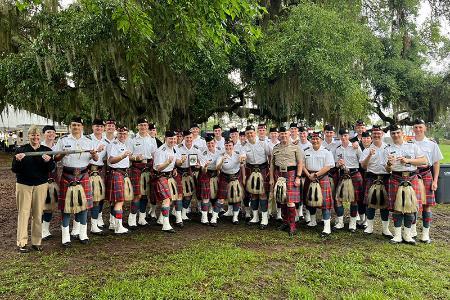 Members of VMI pipe band pose for a group photo in their kilts.