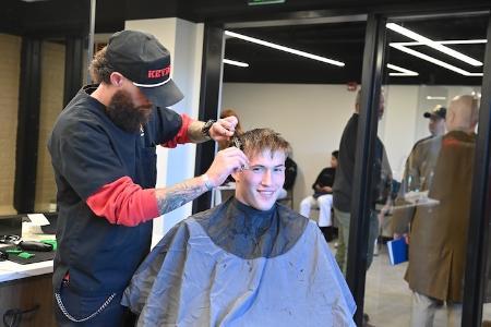 Josh Yarber gives Stephen Dean III ’26 a trim during the grand opening of the new barber shop.