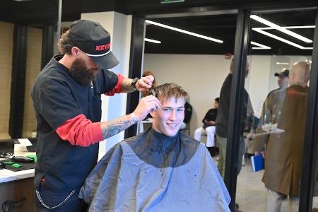 Josh Yarber gives Stephen Dean III ’26 a trim during the grand opening of the new barber shop.