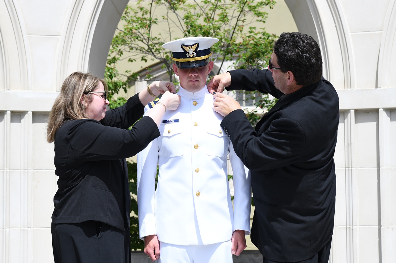Shane McKenna receives his rank pins from his parents.