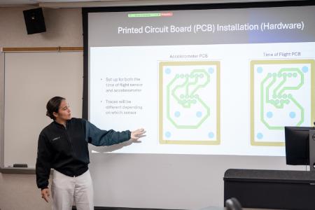 Nicole Samella ’26 explains the use of circuit boards in the project benefitting a disabled veteran.