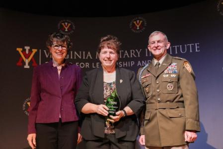 Becky Gwynn accepts the Erchul Environmental Leadership Award from Tanya Denckla Cobb and Col. Dave Gray in Gillis Theater.