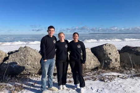Chase Boucher ’27, Kate Patrick ’27, and Jamie Palacio ’27 visit Lake Erie after their victories at the winter air gun championship at Camp Perry, Ohio.