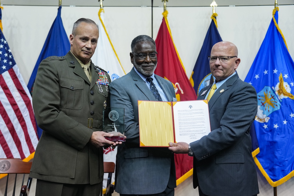 Lt. Gen. David Furness ’87 exhibits the Distinguished Service Award while John Williams ’88 presents the citation recognizing the achievements of Gene Williams ’74 (center).