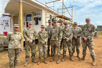 Cadets and leaders pose in front of one of the buildings they helped to construct during a Habitat for Humanity build.