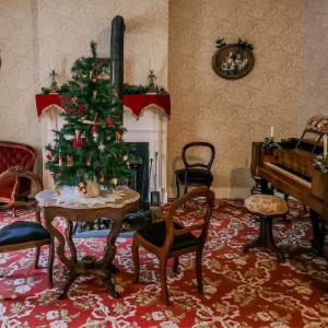A room in the Jackson House Museum is decorated for Christmas with festive touches including a tree.