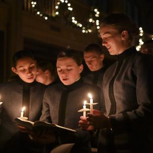 Cadets sing and hold candles in Memorial Hall.