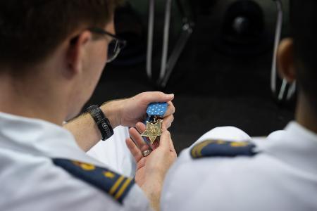 A cadet admires Carpenter’s Medal of Honor in Cameron Hall during the moderated interview.