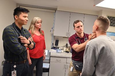 Allen Xu ’21 and Dr. Melissa S. Krawiec ’01 observe as Thaddeus Wegrzyn ’22 examines a cadet in the VMI Infirmary.