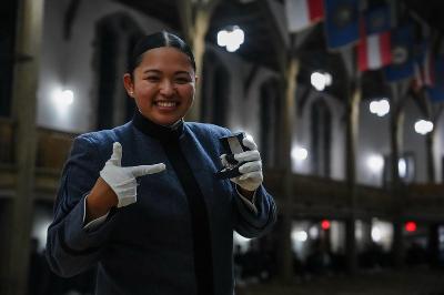 Member of the Class of 2027 points to her combat ring and smiles after collecting it in Memorial Hall.