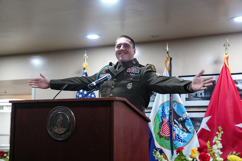 Aviles beams with pride at the podium, arms outstretched.