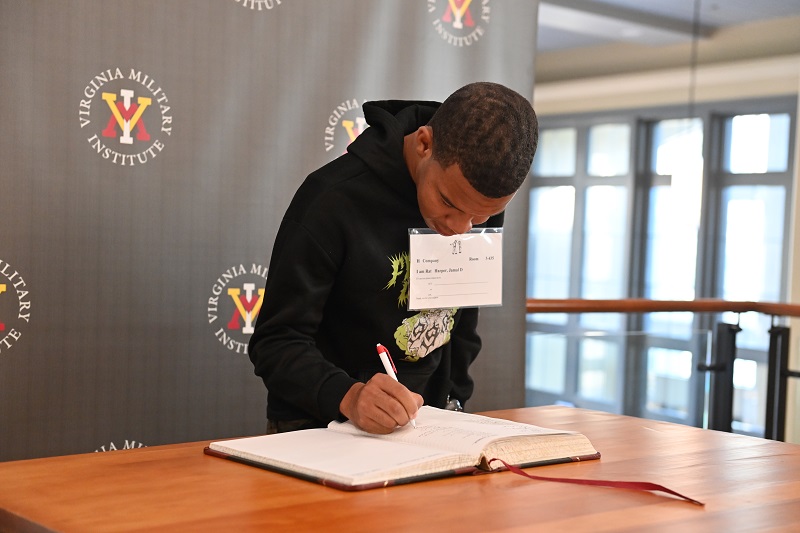 A new freshman at VMI - known as a rat - signs the Matriculation Book to officially commit to No Ordinary College.