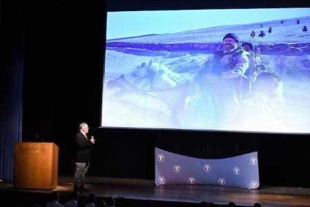 Master Sgt. Christopher C. Spence displays the iconic photograph he took of a Horse Soldier during his speech in Gillis Theater Sept. 10.