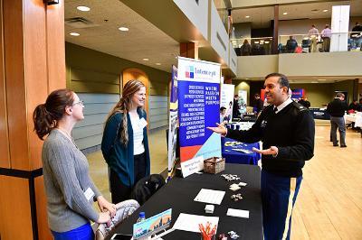 Lt. Col. Ammad Sheikh, director of Career Services, speaks with career fair attendees