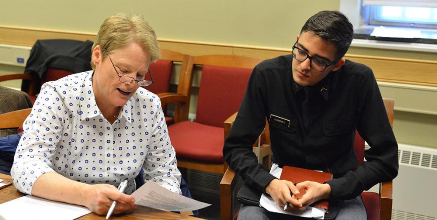 Lee Byrd reads her memoir to cadet Carlos Fernandes.