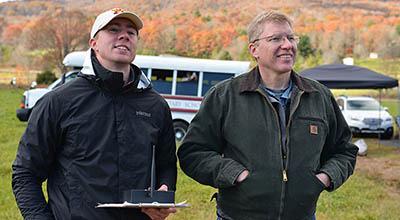 Col. James Squire and Clay Penney '19 look on as their rocket prototype takes off.