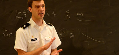 Professor Greg Hartman in front of blackboard lecturing.