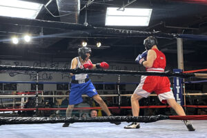 VMI boxing club member Ben Wigert ’24 (in red), a 155-pound novice from Cedar Park, Texas, competes during the second annual College Fight Night at Georgia Tech.