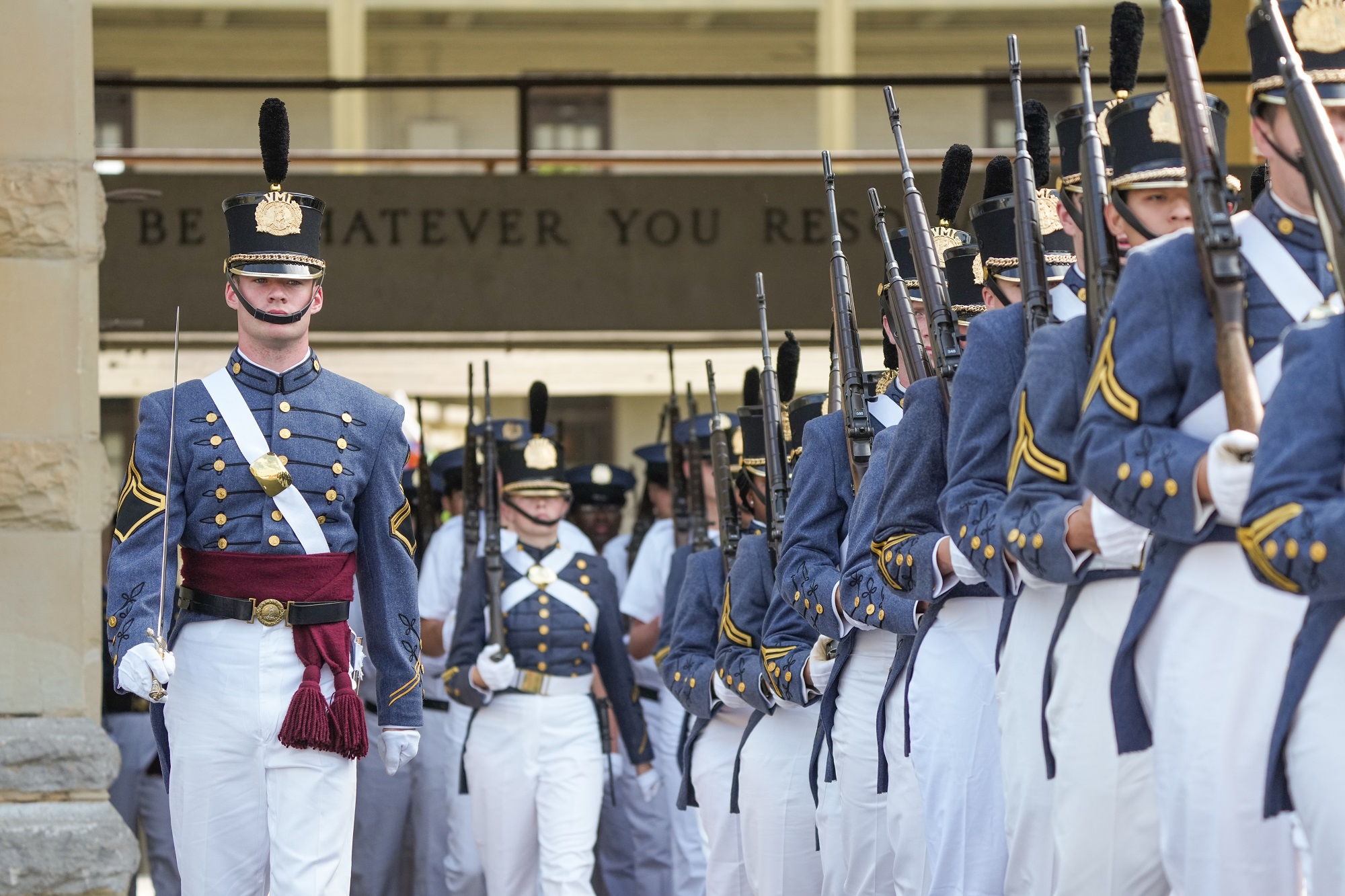 VMI cadets in full dress uniform, marching in formation out of barracks for a parade.