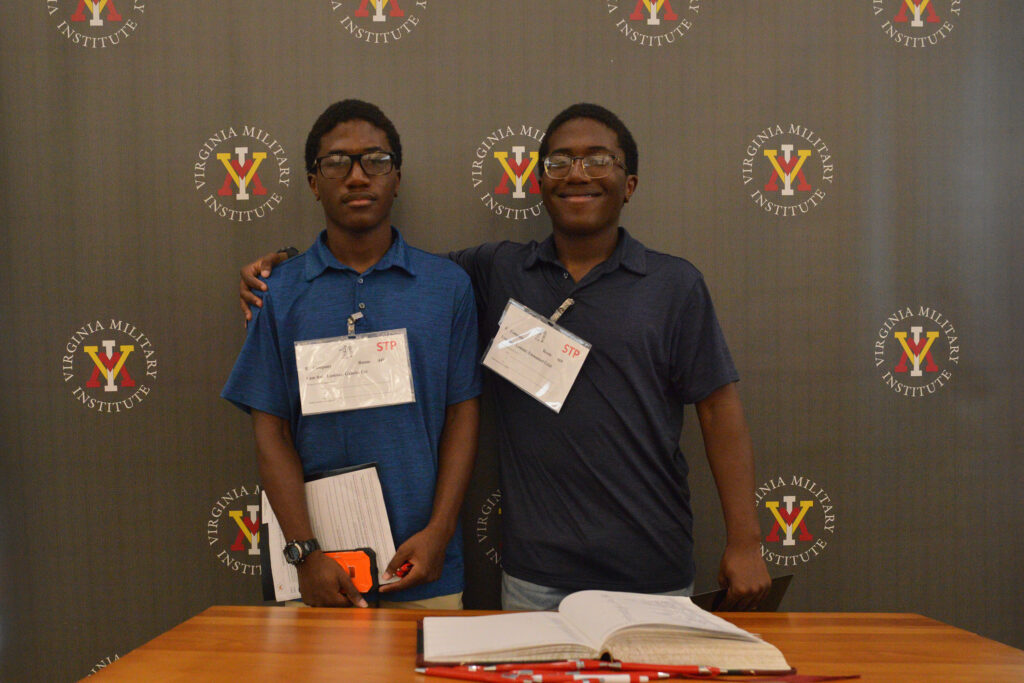 Emmanuel Lamour embraces his identical twin brother, Gabriel, after they both sign the Matriculation Book.