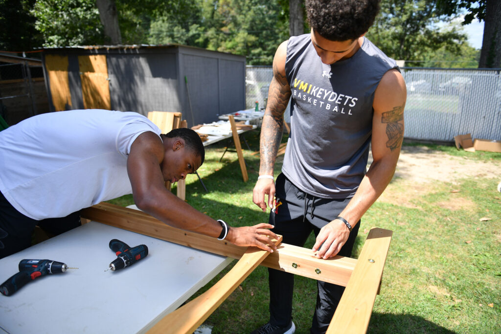 Basketball athletes, AJ Clark ’27 and Rickey Bradley Jr. ’26, work together building the frame of the playset.