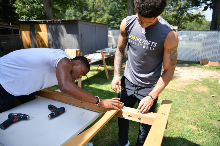 Basketball athletes, AJ Clark ’27 and Rickey Bradley Jr. ’26, work together building the frame of the playset.