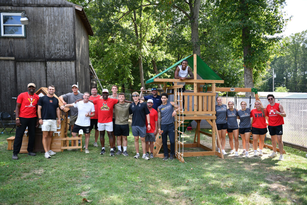 VMI cadets and athletic staff celebrate after completing the playset and playhouse for Oakley Clements of Buena Vista.