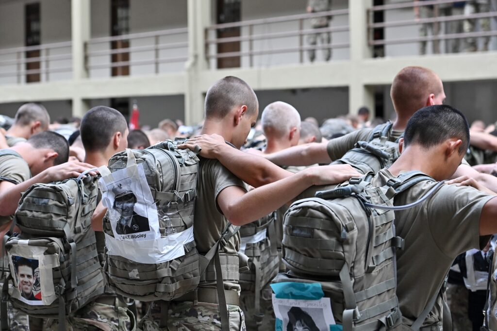 VMI cadets link arms and bow their heads, while carrying backpacks with the names of victims of the Sept. 11, 2001 terror attack.