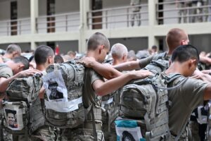 VMI cadets link arms and bow their heads, while carrying backpacks with the names of victims of the Sept. 11, 2001 terror attack.