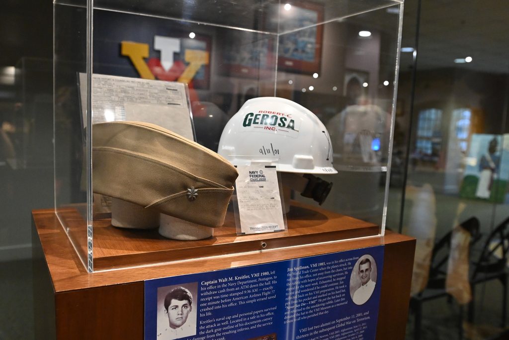 Hat, hard hat, and ATM receipt in a museum case.